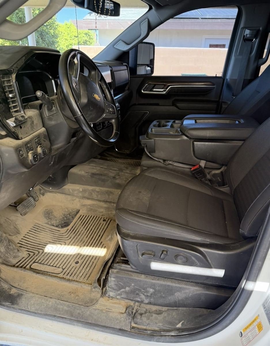 Same truck interior before, with muddy floor mats and dirty floorboards